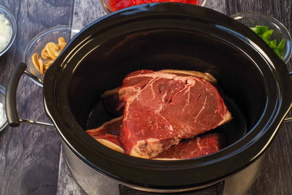 Steak in the bottom of a slow cooker