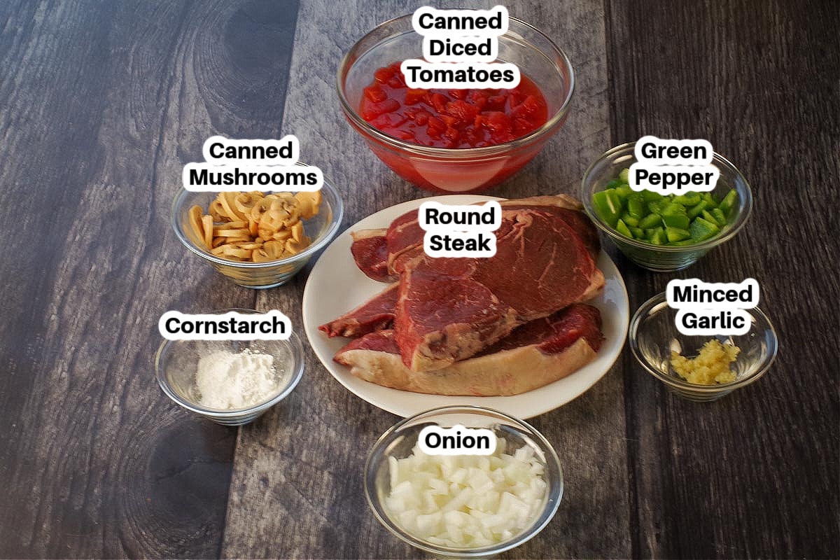 ingredients in slow cooker swiss steak in glass bowls, labelled