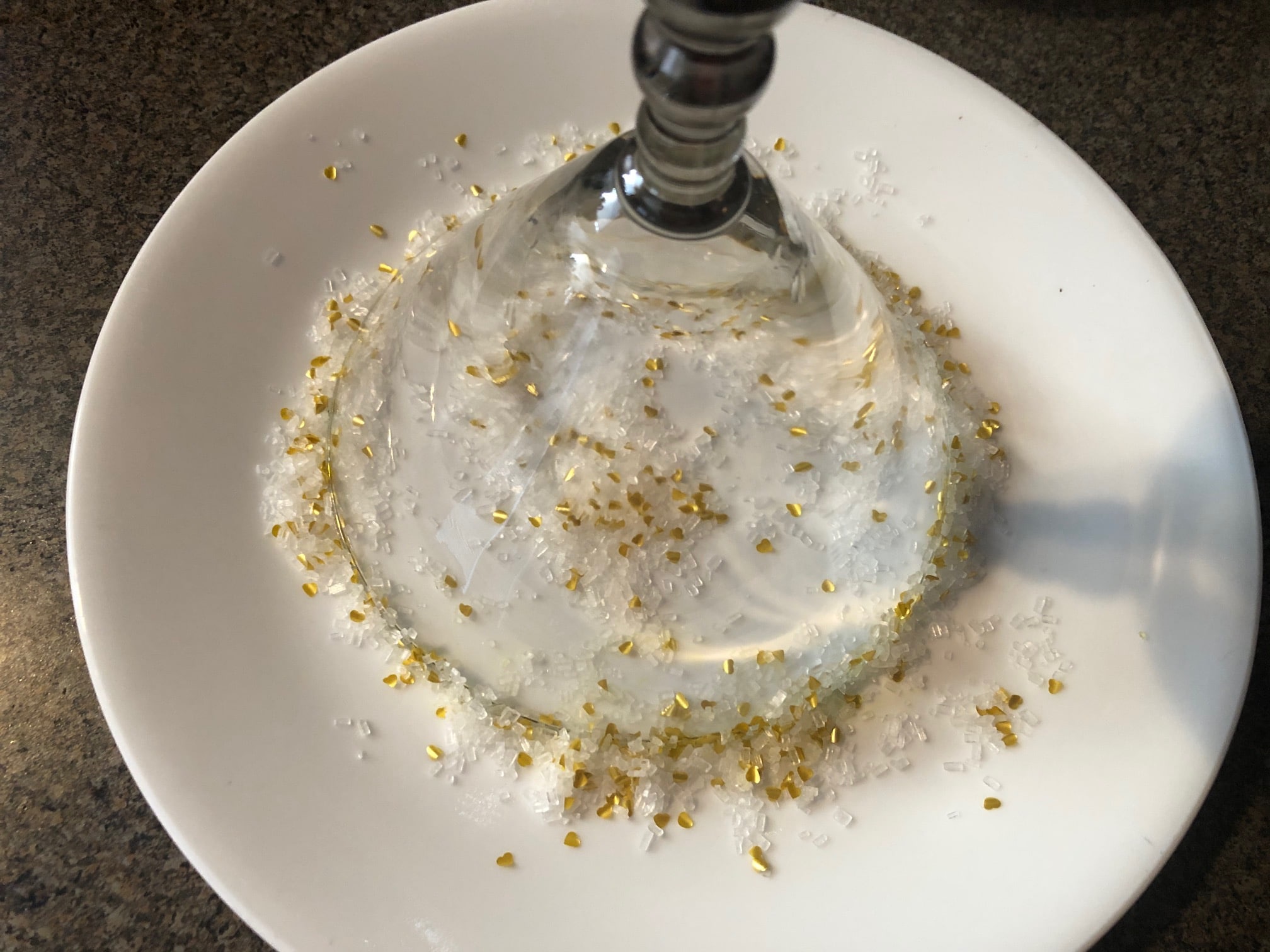 glass upside down on plate with sparkling sugar and glitter