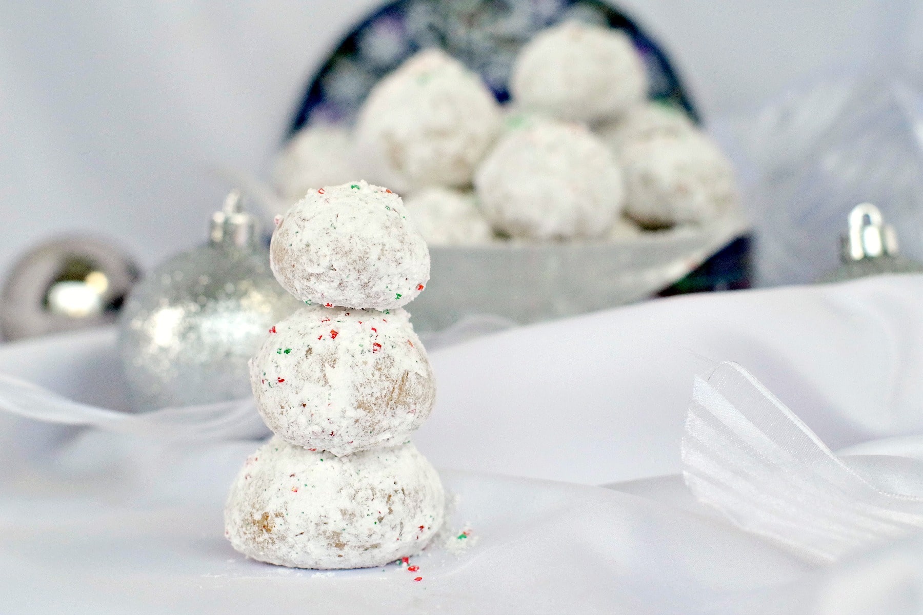 Gingerbread Snowball Cookies piled up to look like a snowman