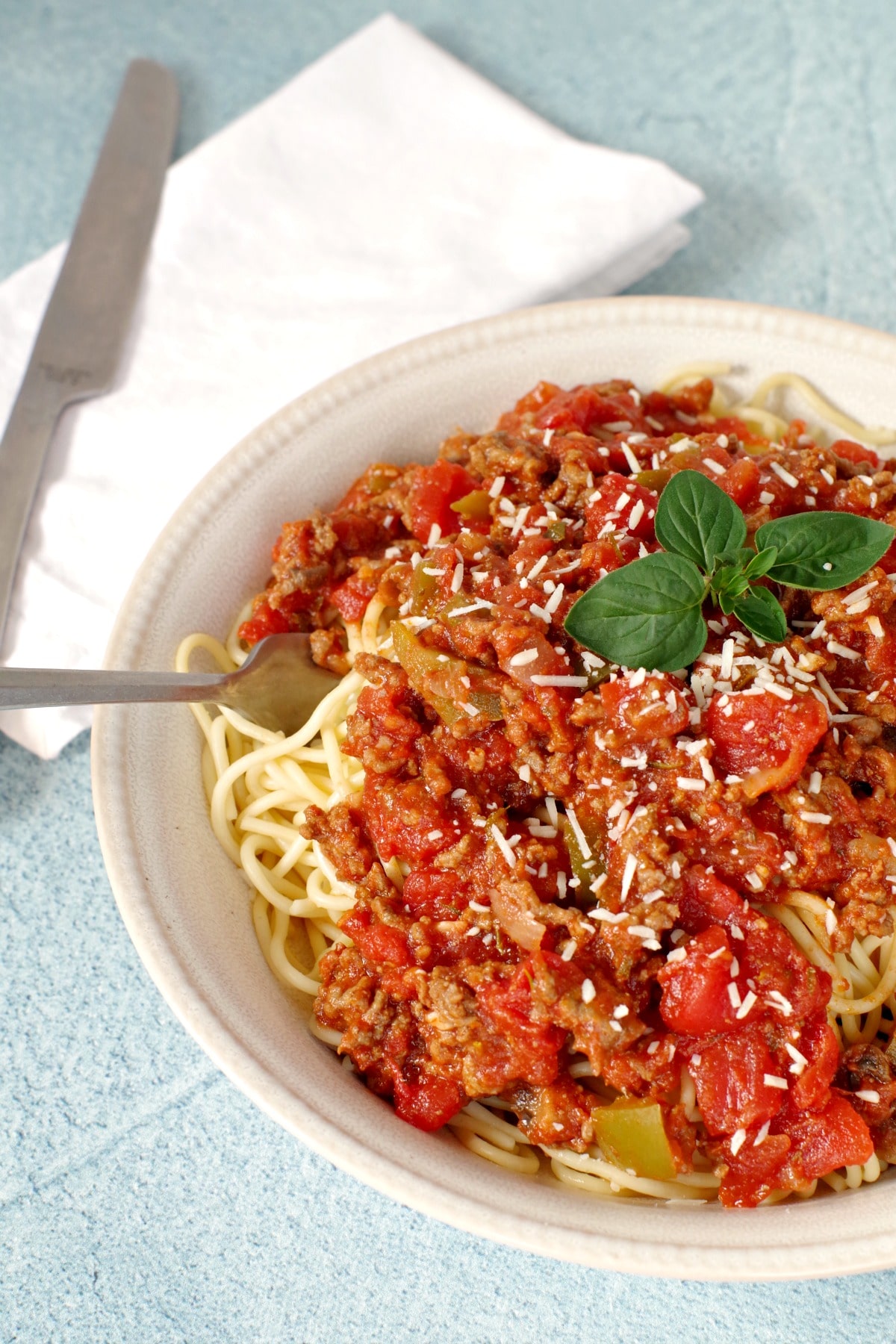 Spaghetti and meat sauce in a beige bowl