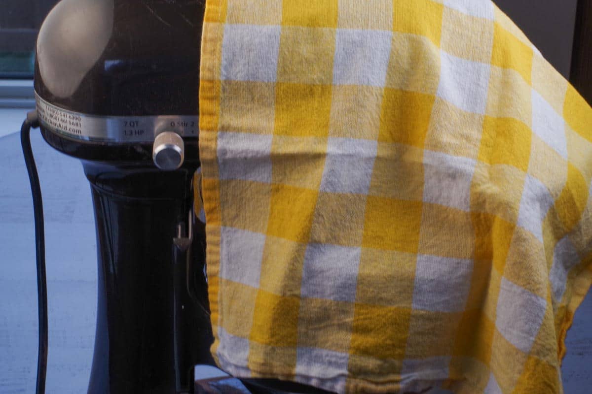 stand mixer covered with a white and yellow checkered tea towel