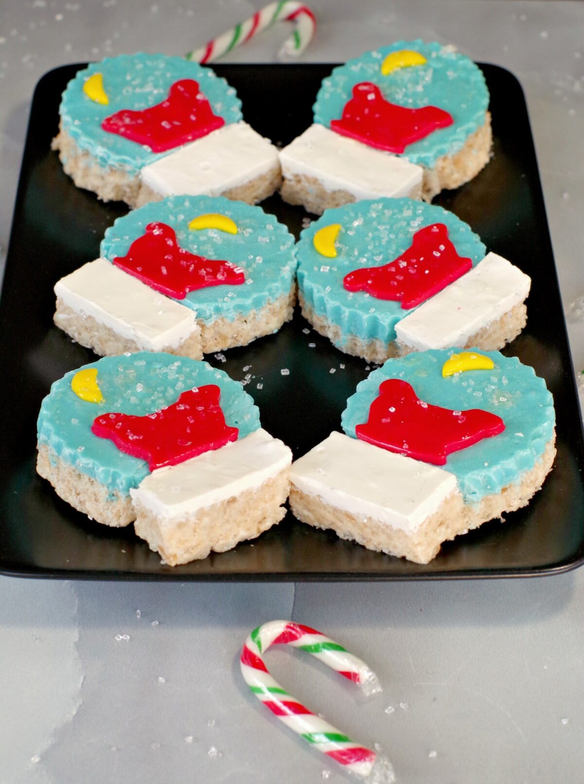 Rice Krispie Snow Globes on black tray with candy canes