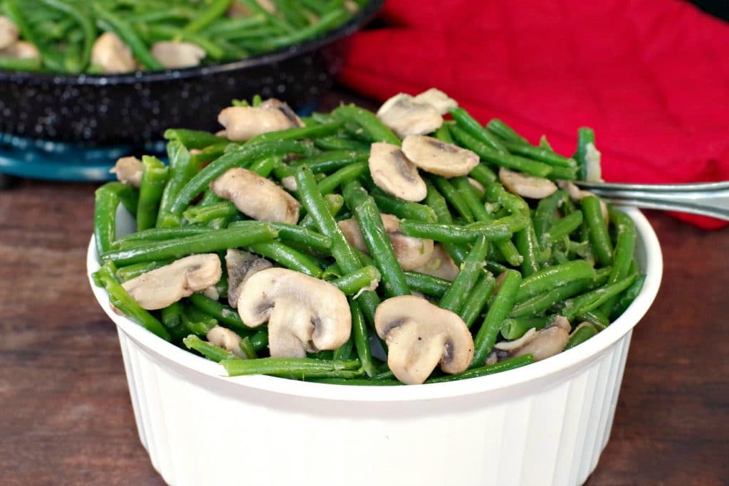 green beans and mushrooms in a white round casserole dish