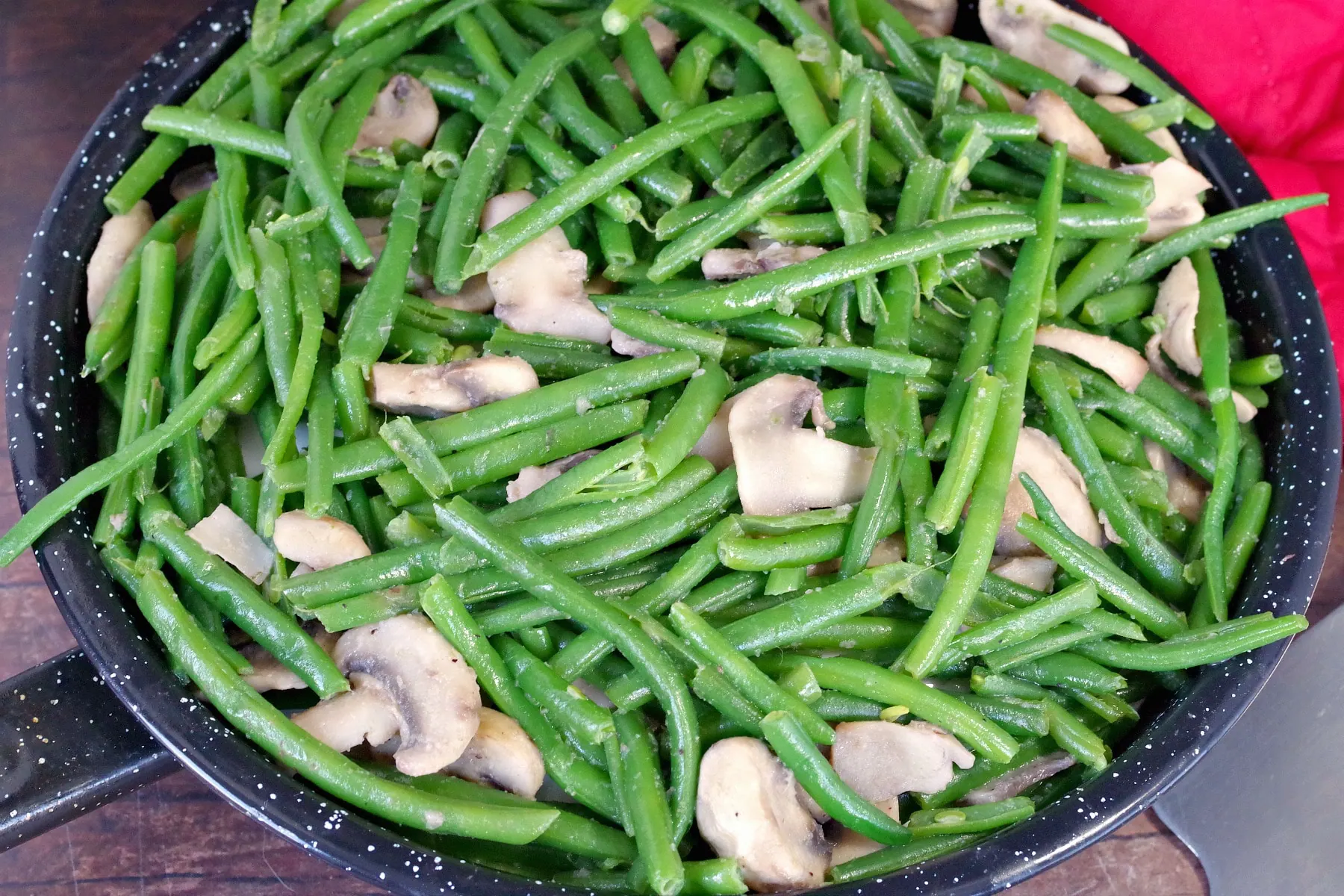 Close up of green beans and mushrooms in a skillet