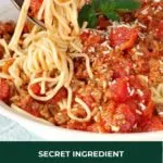 spaghetti and meat sauce with spaghetti being twirled with a fork and spoon