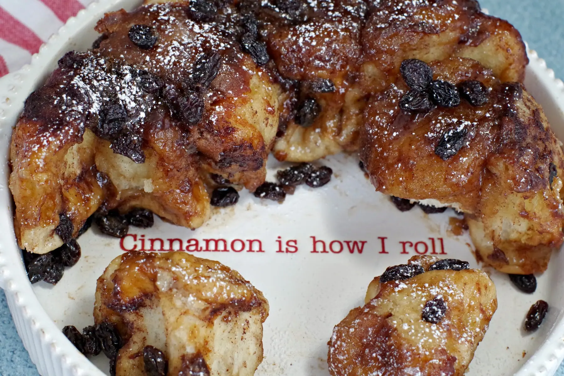 Overnight Cinnamon Sticky Buns in white dish with writing "cinnamon is how I roll)
