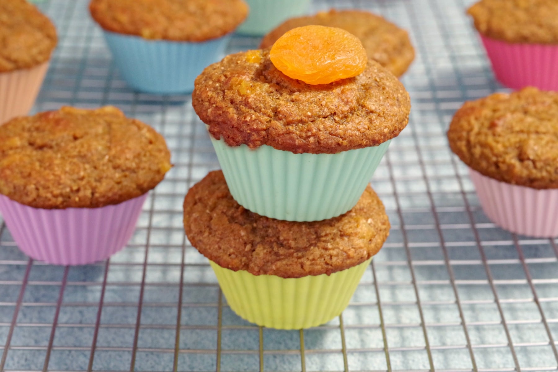 2 pumpkin bran muffins with an apricot on top and more muffins in background