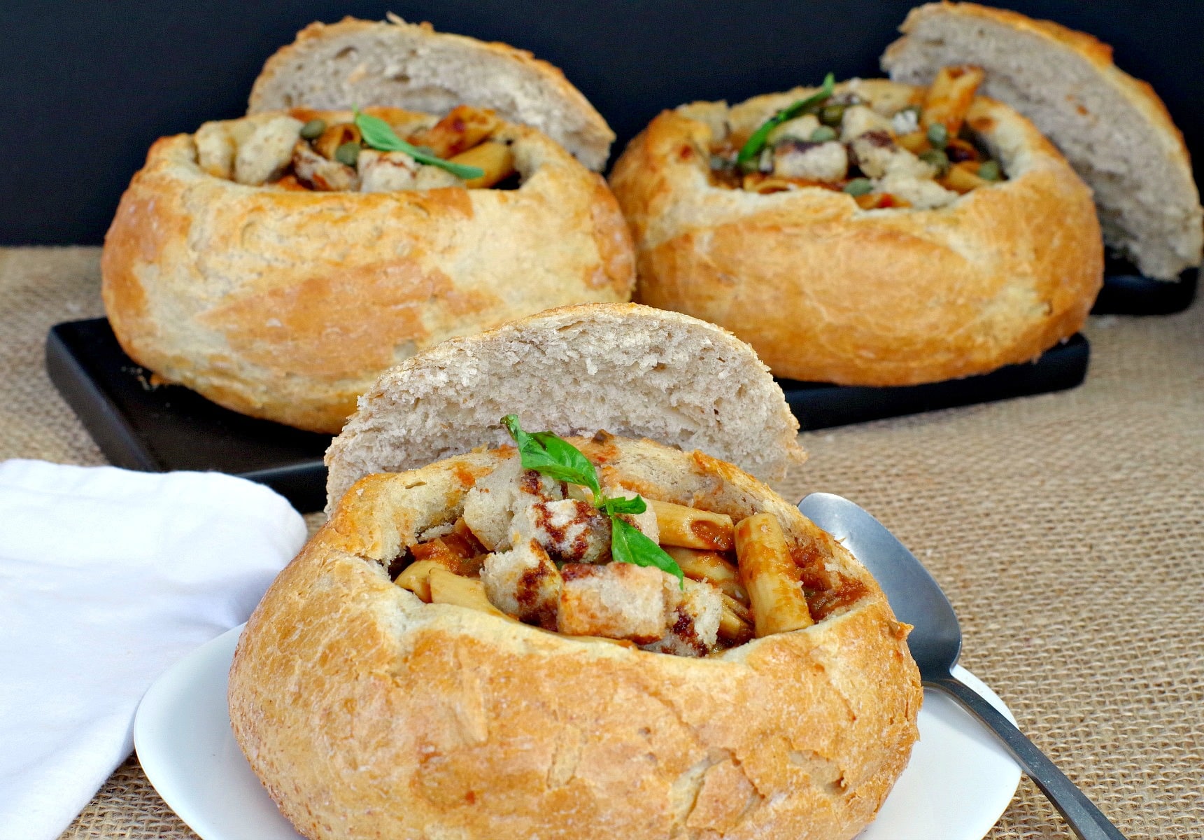3 bread bowls filled with Panzanella Pasta Soup (back 2 on black tray)