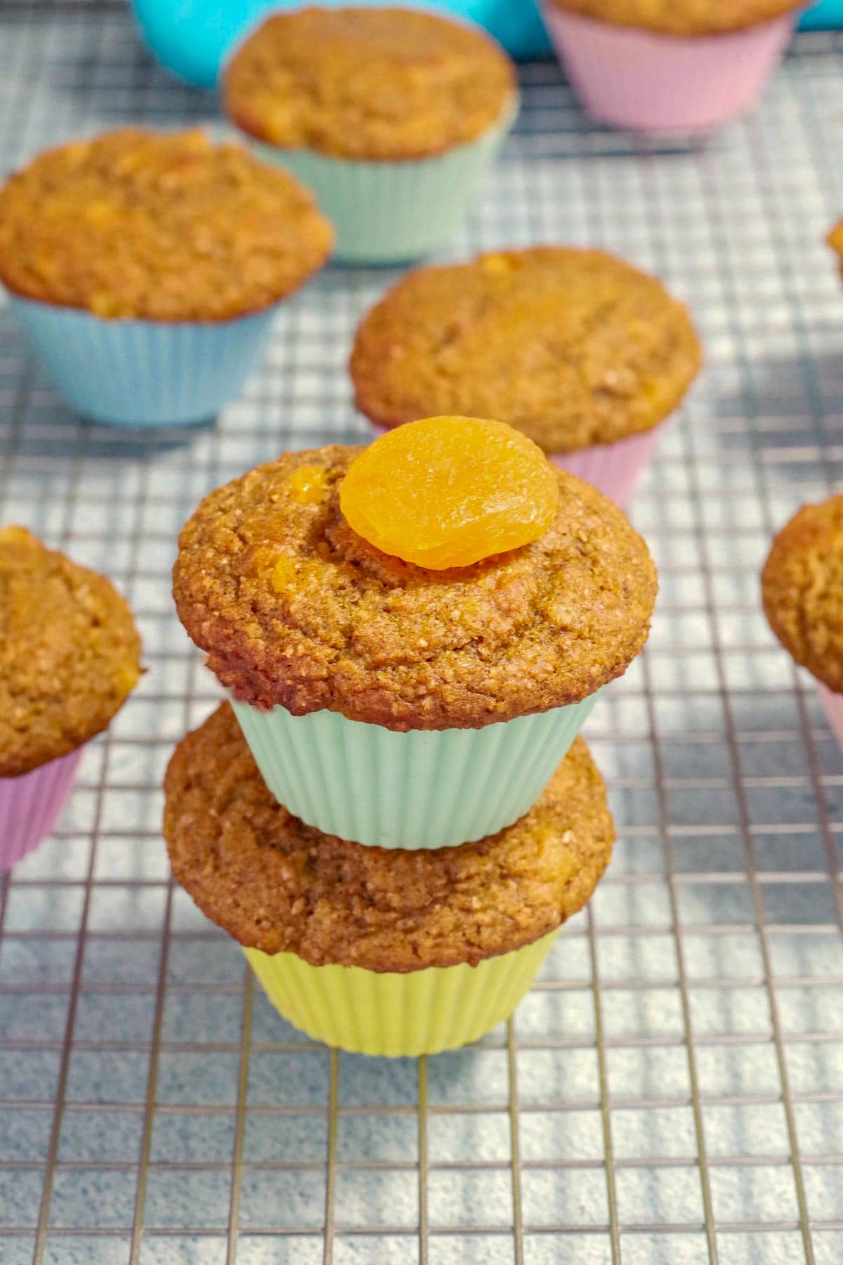 2 pumpkin bran muffins stacked on top of each other on a cooling rack