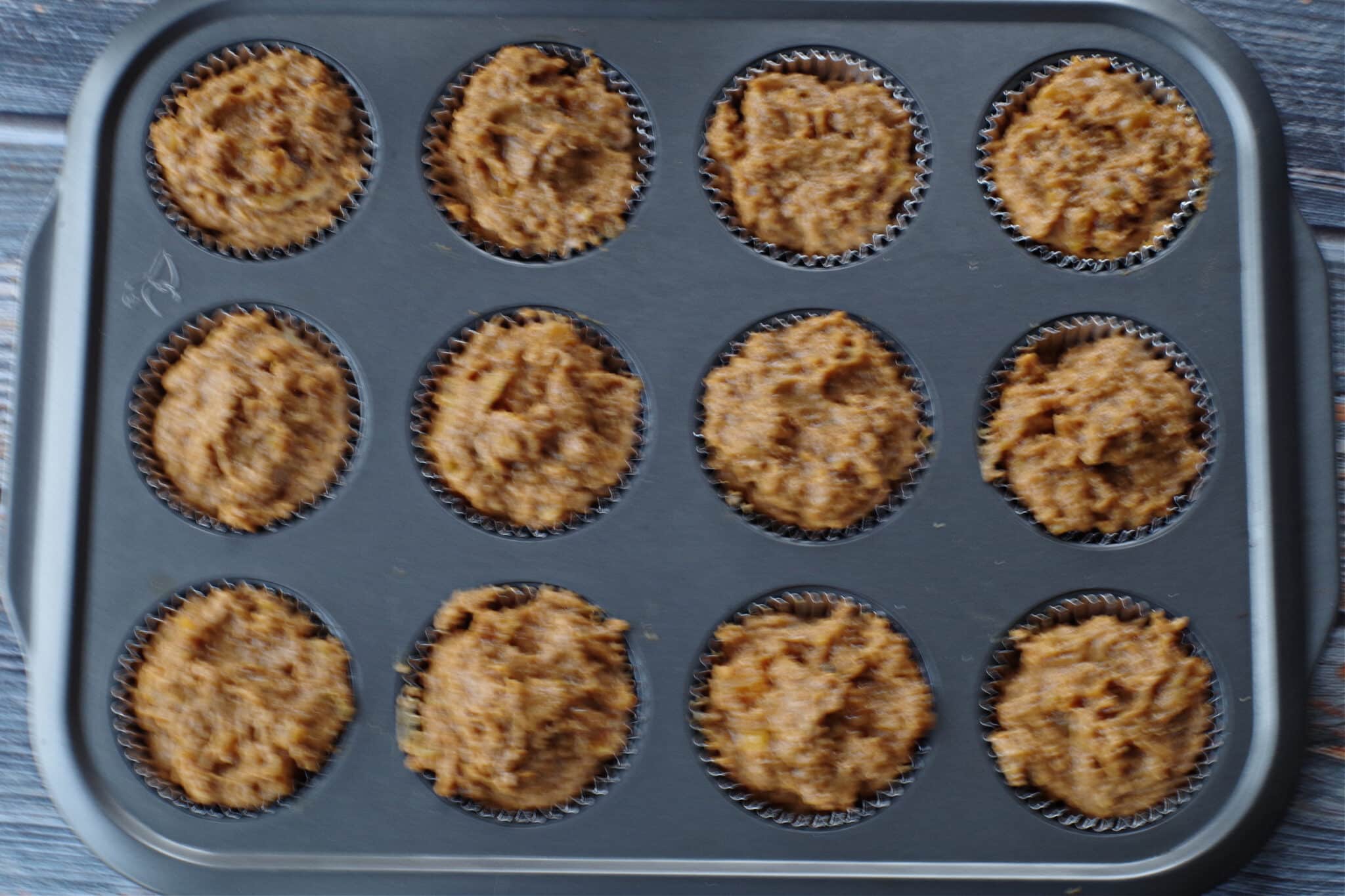 batter filling muffin tins to the top