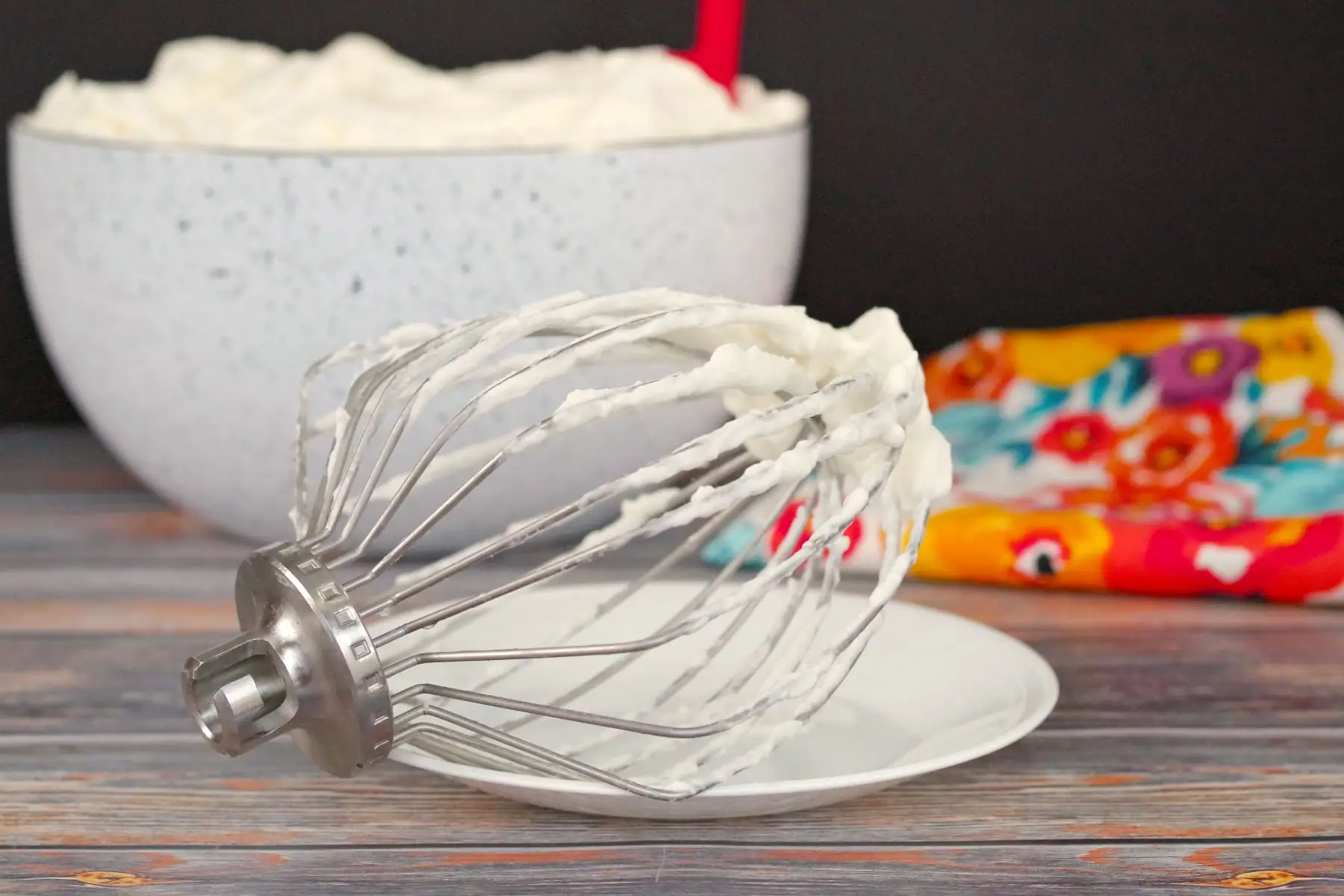 whipped cream icing in bowl with beater in front