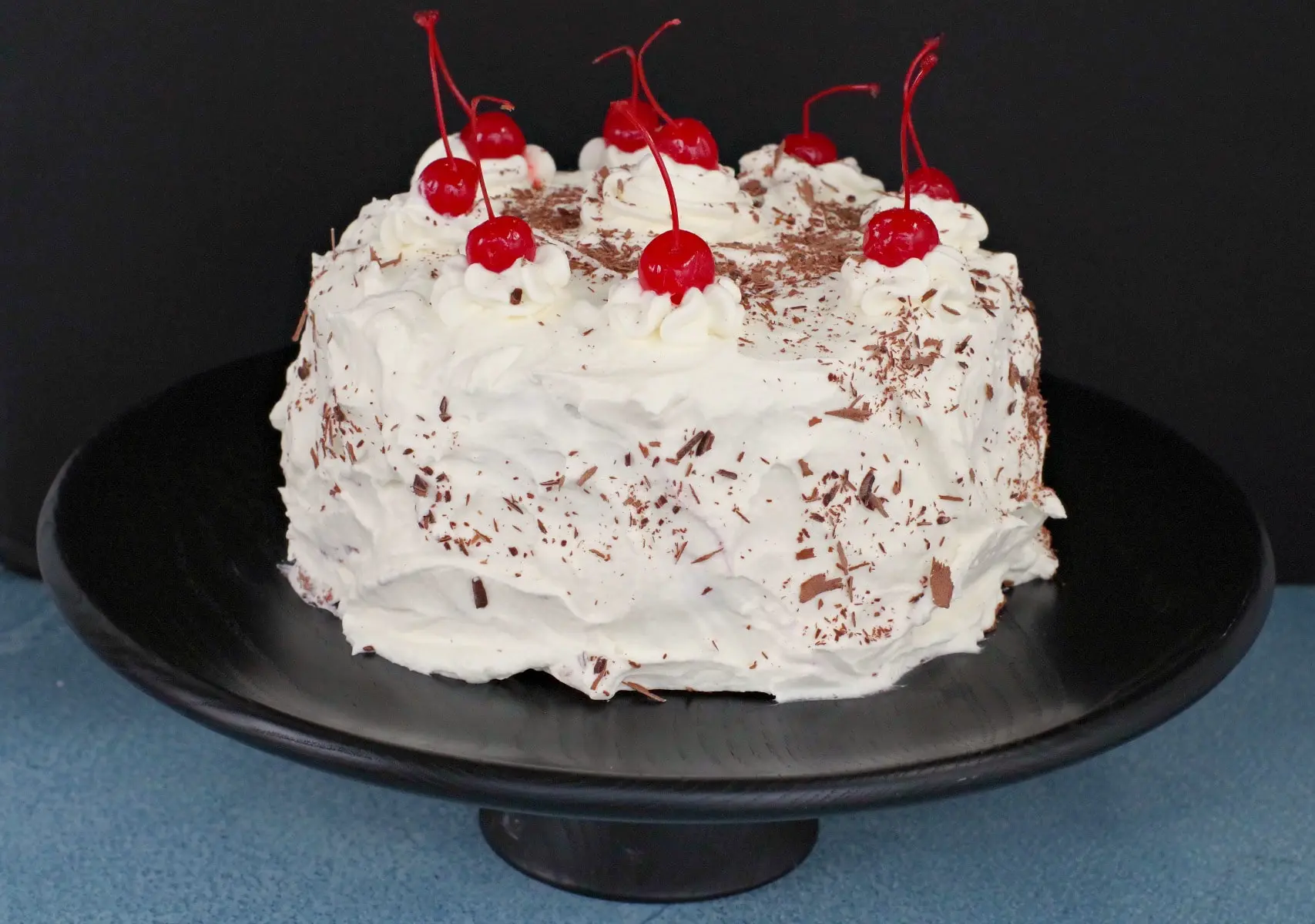 Whole black forest cake on black stand