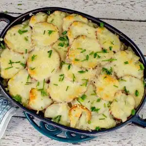 Potato casserole with spinach and beef in blue casserole dish
