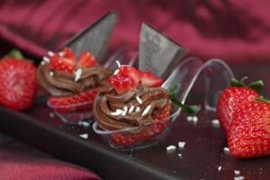 2 Chocolate Avocado & Strawberry mini desserts on a spoon on a black appetizer tray