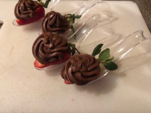 Chocolate avocado mousse piped on half a strawberry