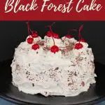 Pinterest pin with white text on red background on the top and bottom and a whole black forest cake with cherries in the middle