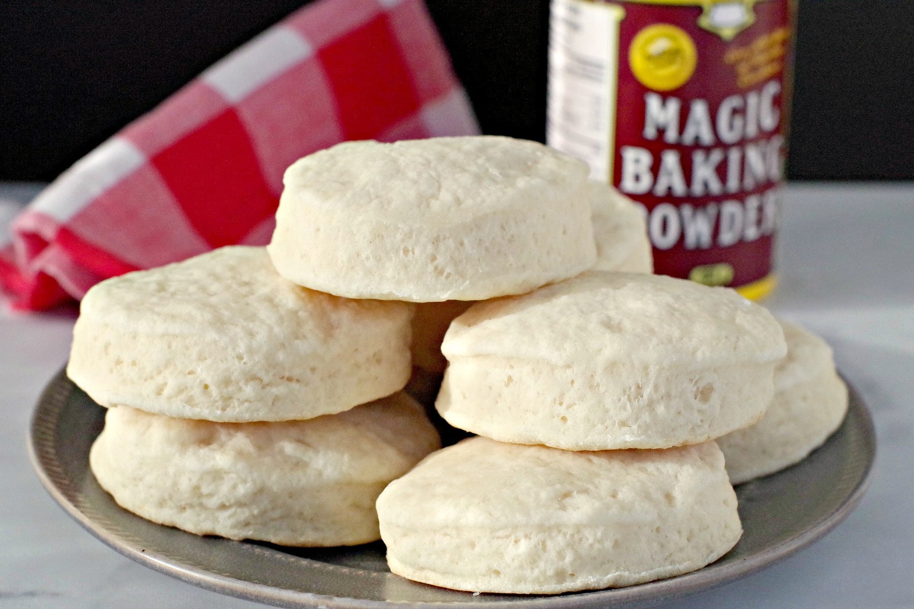 baking powder biscuits on a plate with baking powder in background