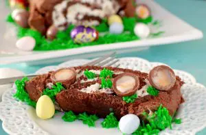 Easter Creme Egg Swiss Roll Cake on a white plate with cake in background