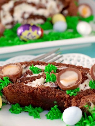 Easter Creme Egg Swiss Roll Cake on a white plate with cake in background