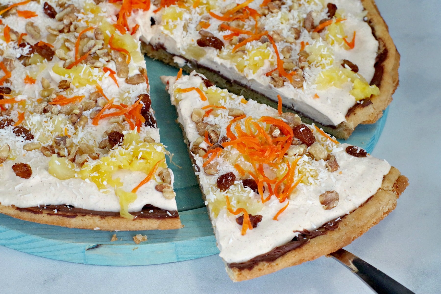 carrot cake dessert pizza slice being removed from pizza