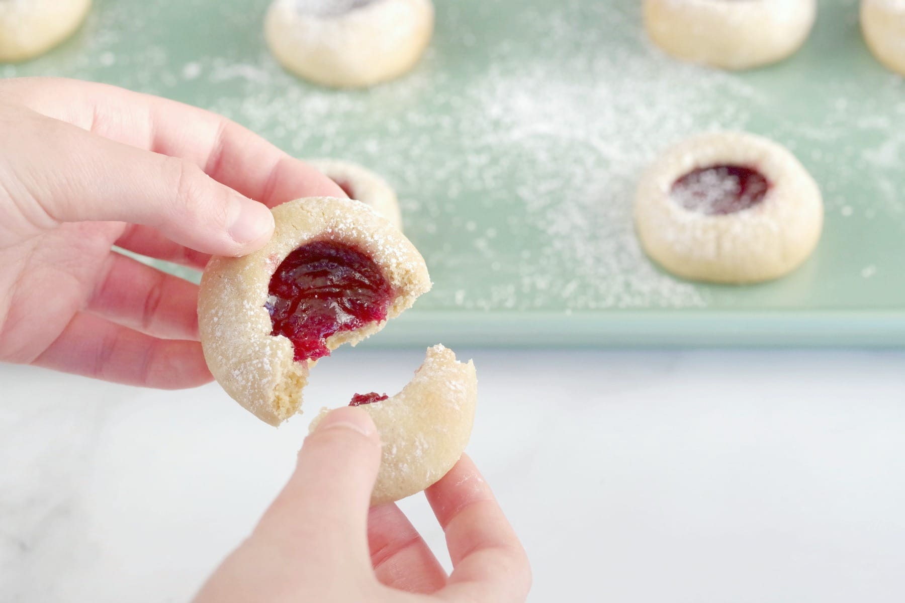 raspberry jam cookie being broken in half