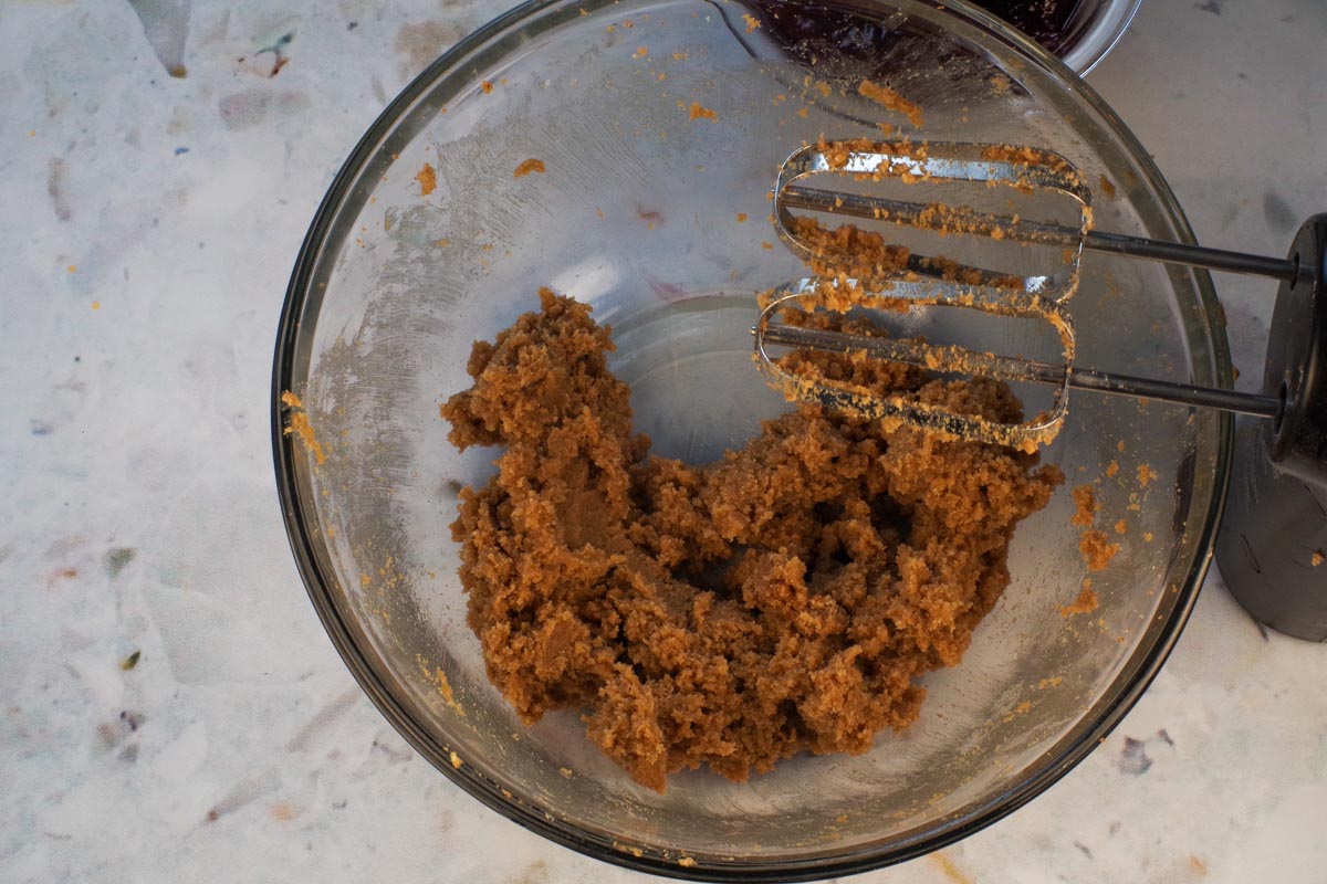 Brown Sugar and Butter beaten together in large glass bowl, with beaters over bowl.