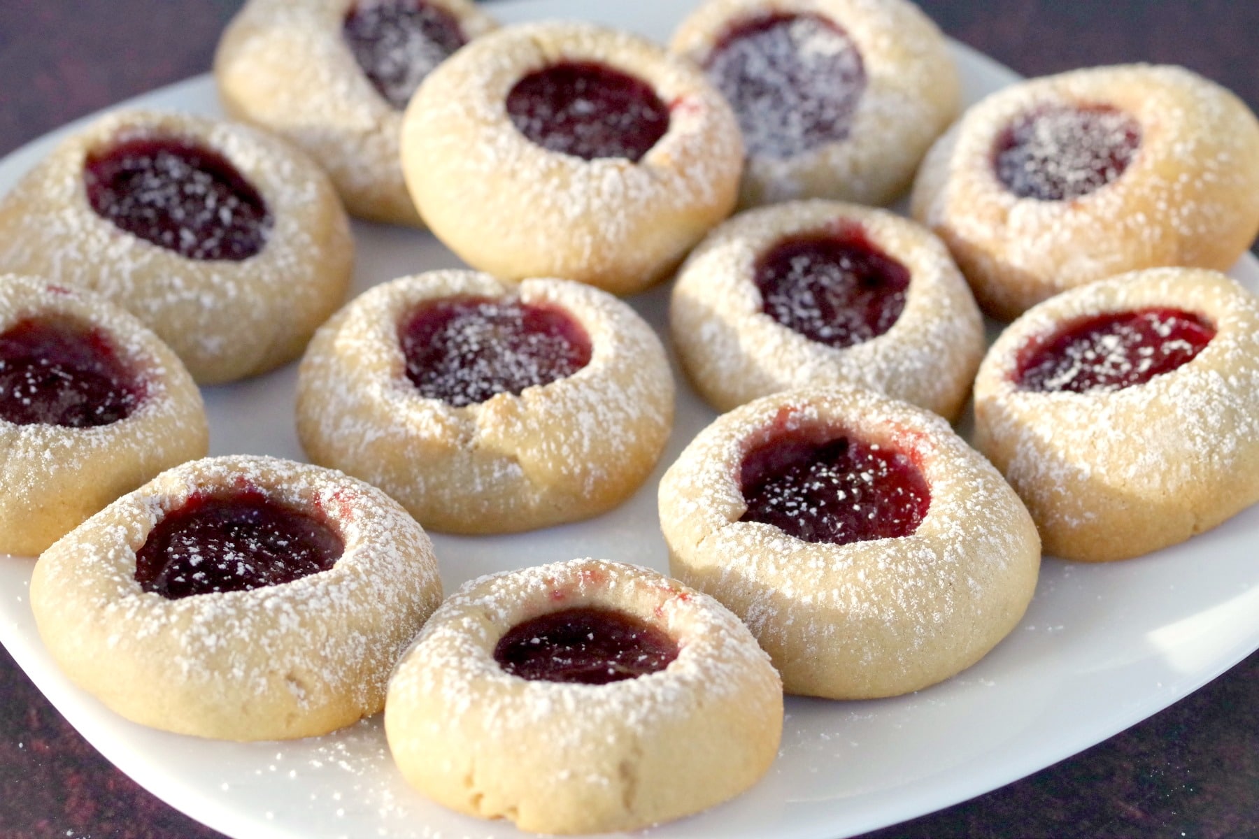 raspberry jam cookies on a white plate