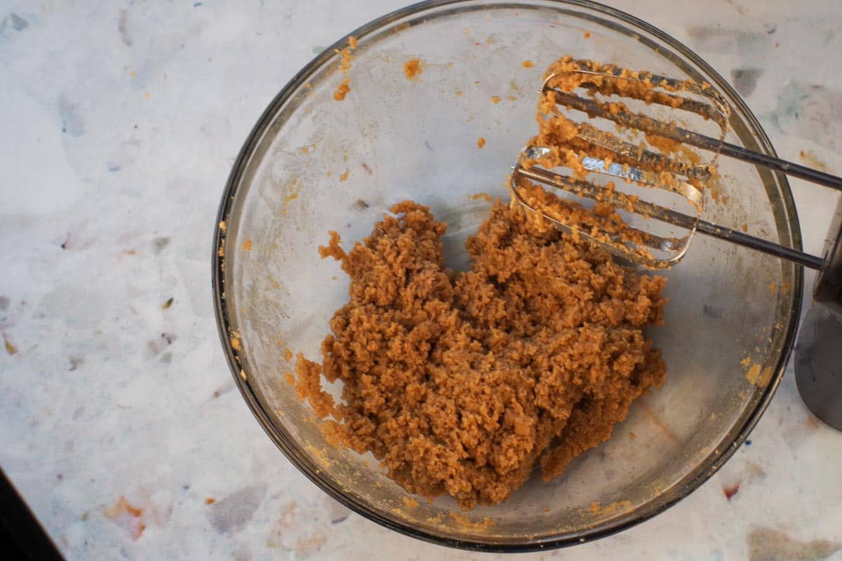 Egg beaten into brown sugar and butter mixture in large glass bowl.