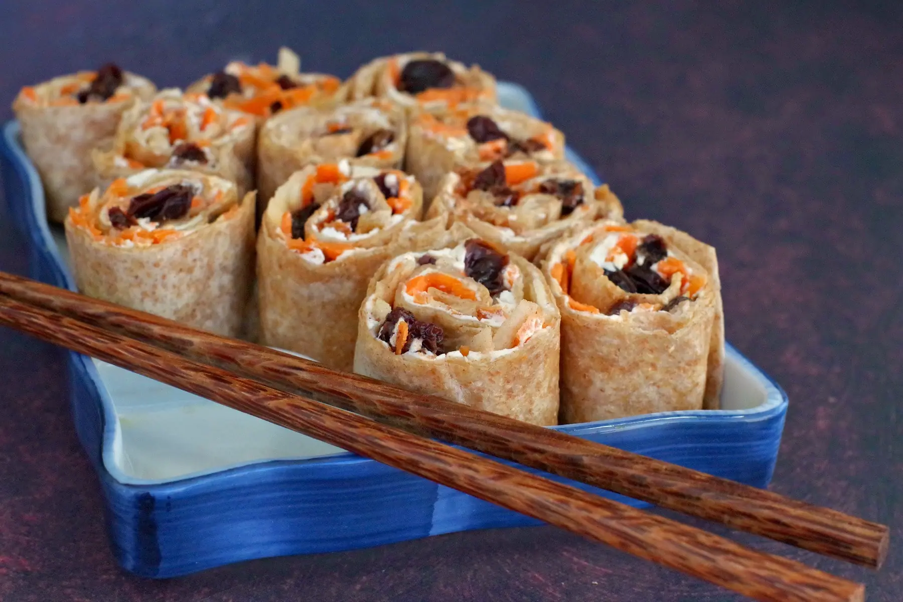 raisin sushi on sushi tray with chopsticks