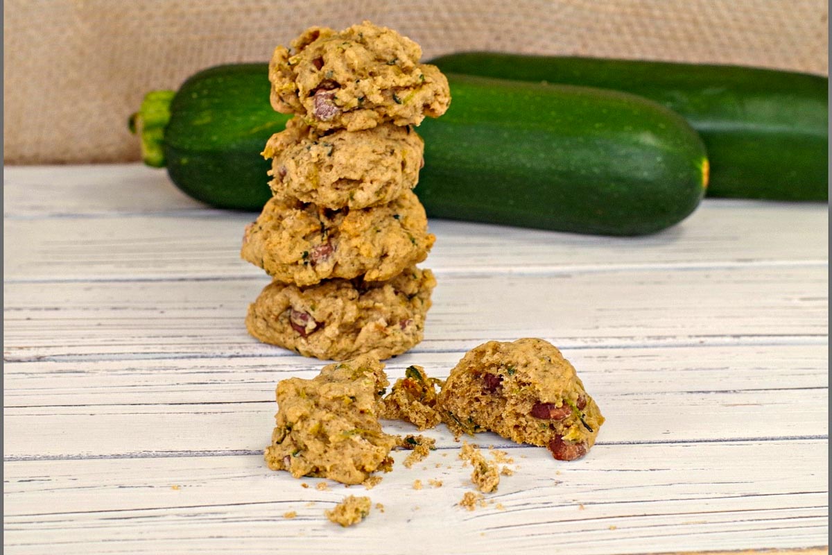 zucchini chocolate chip cookies stacked in back with one broken on in front