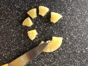 pineapple ring being cut into 6 pieces