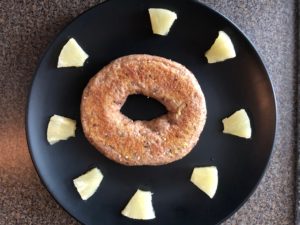 bagel on plate with pineapple pieces
