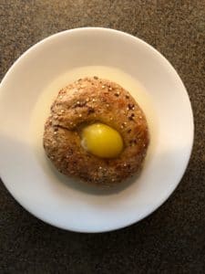 bagel with egg cracked into middle