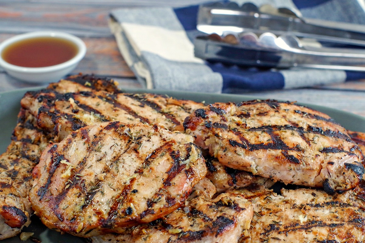 Several pieces of marinated grilled lemon pork piled on a platter