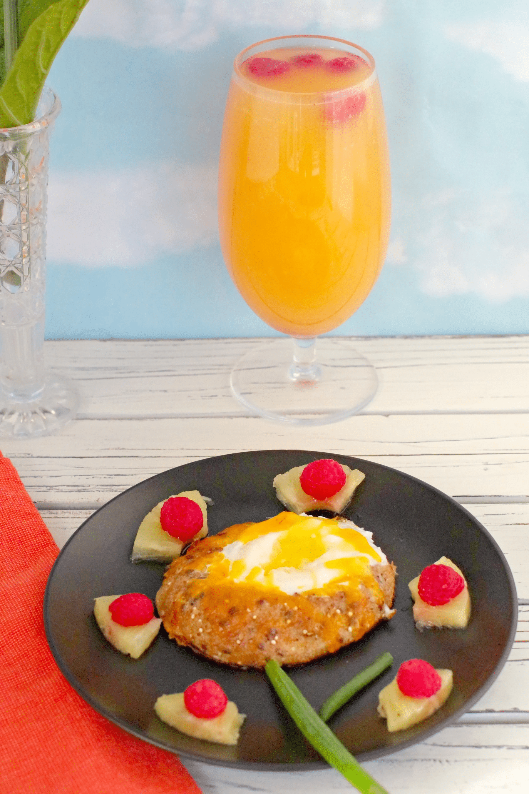 bagel in a hole with mimosa mocktail in background