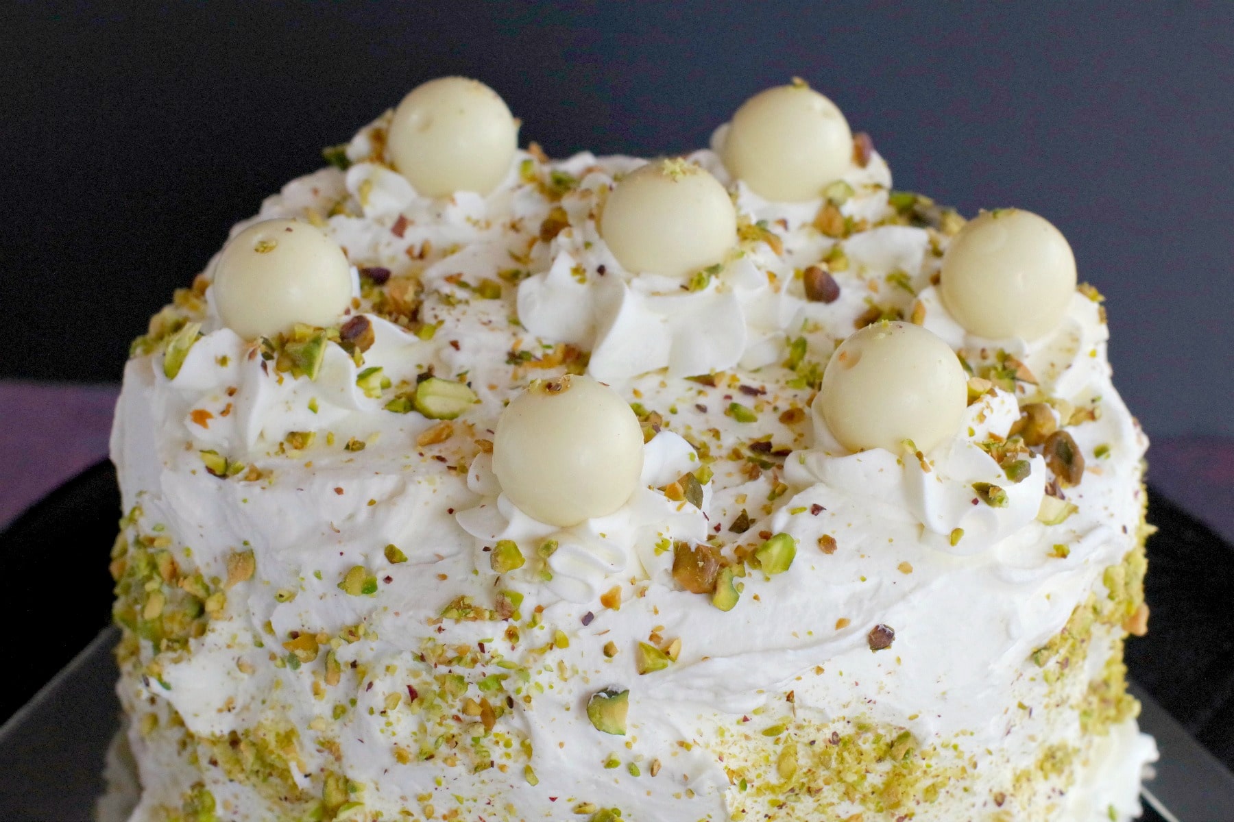 Top of White Chocolate Pistachio cake on black stand