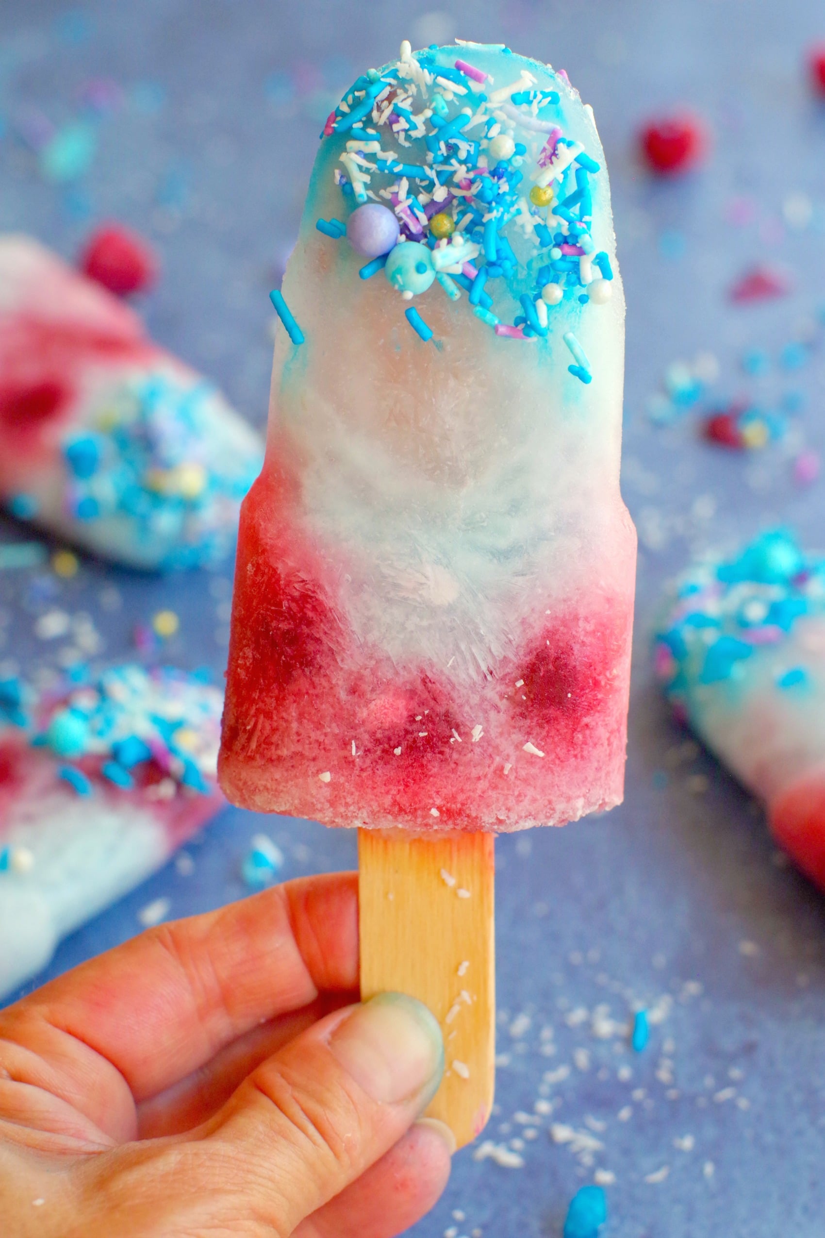 blue raspberry popsicle being held up