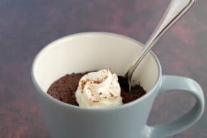 microwave chocolate banana mug cake with a spoon in it