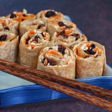 tortilla pinwheels on a blue sushi platter with chopsticks
