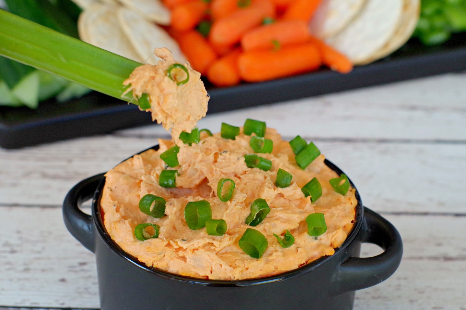 celery being dipped into buffalo chicken dip