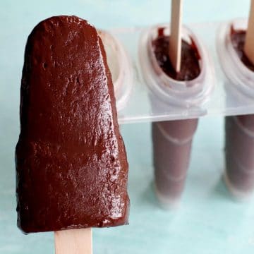banana fudge popsicle with popsicle mold in the background