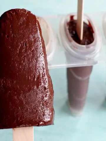 banana fudge popsicle with popsicle mold in the background