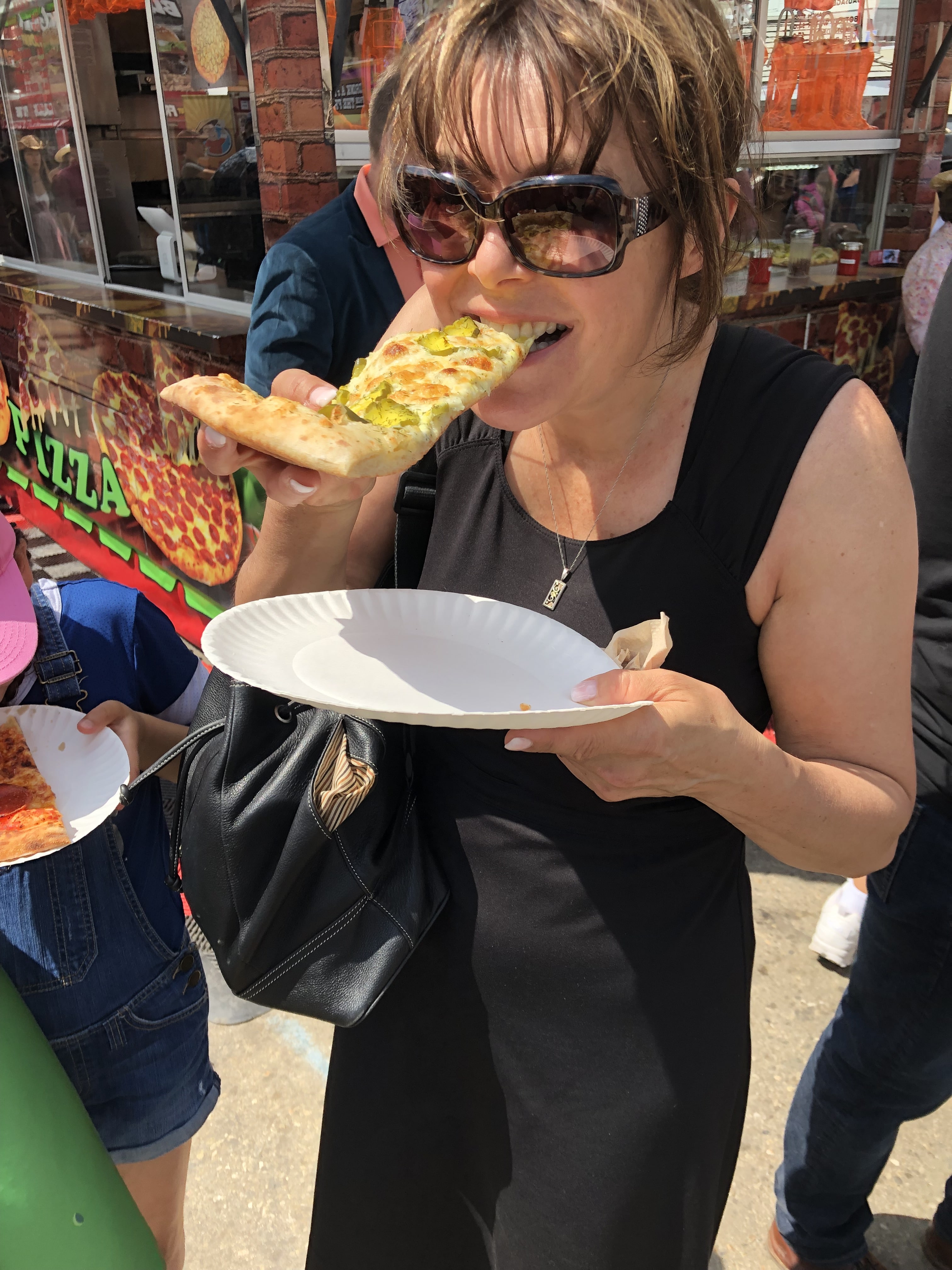 Terri eating pickle pizza at Calgary Stampede