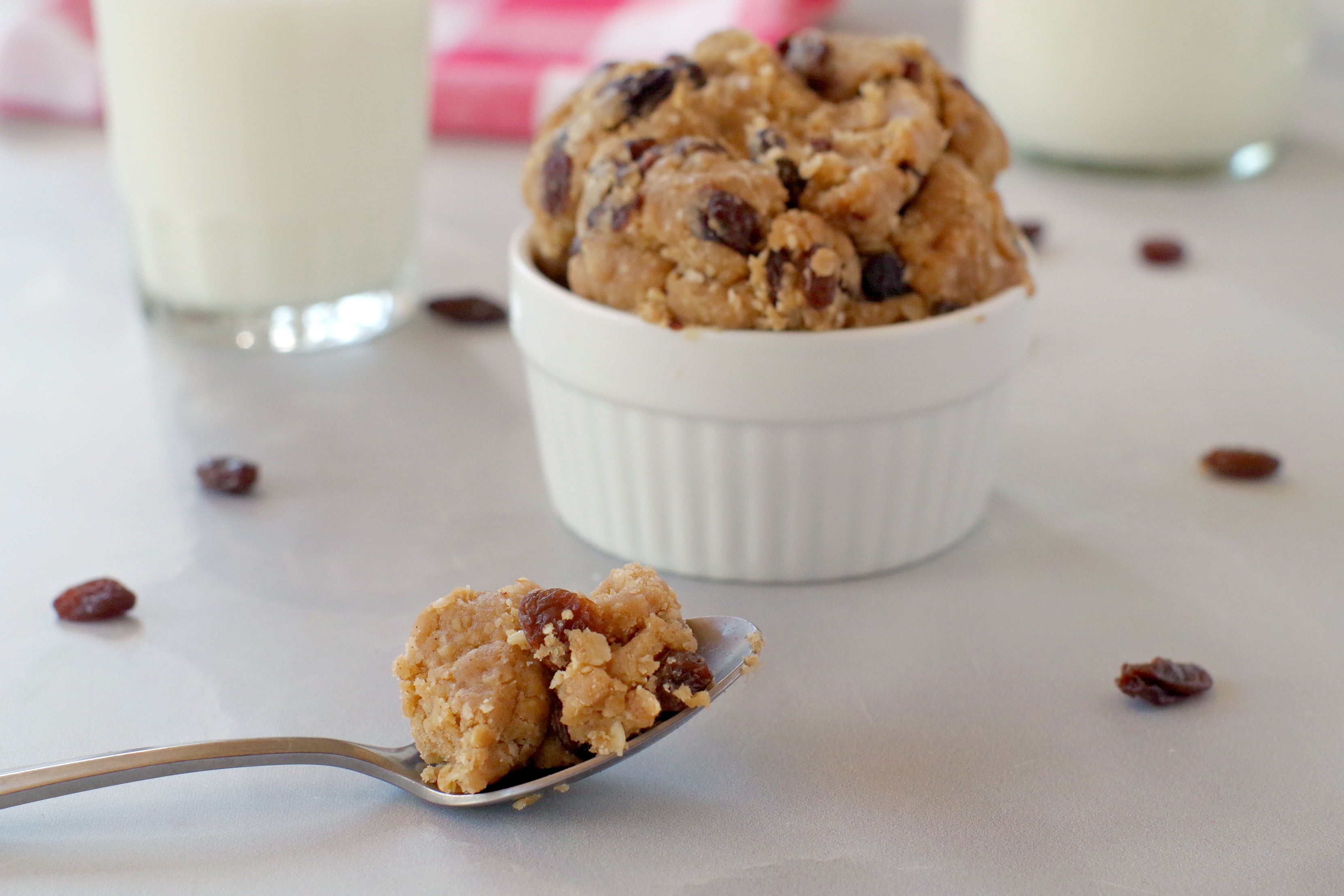 homemade edible cookie dough on spoon with bowl of cookie dough in the background