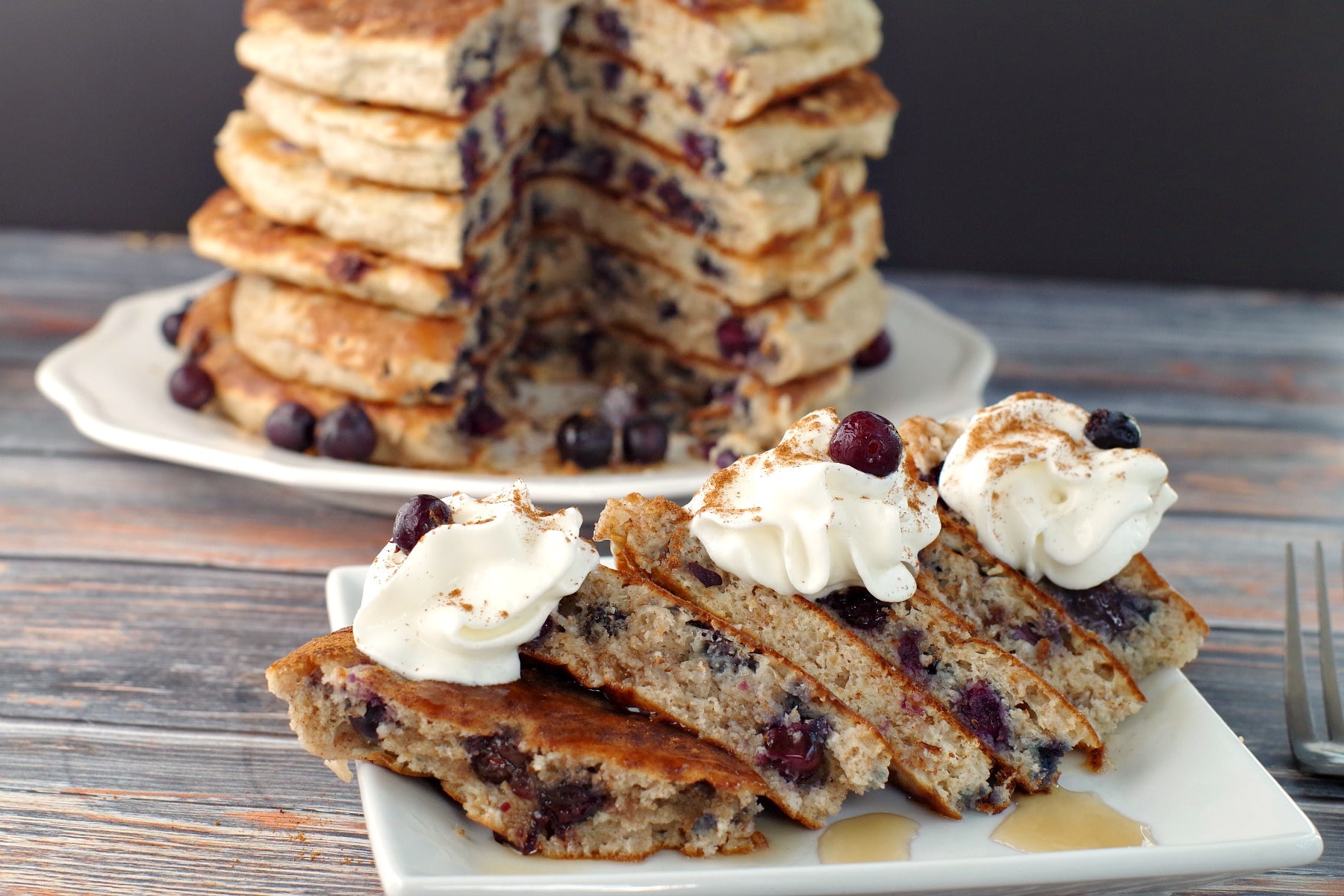 cut out Saskatoon berry pancakes (from stack) on white plate with stack in background