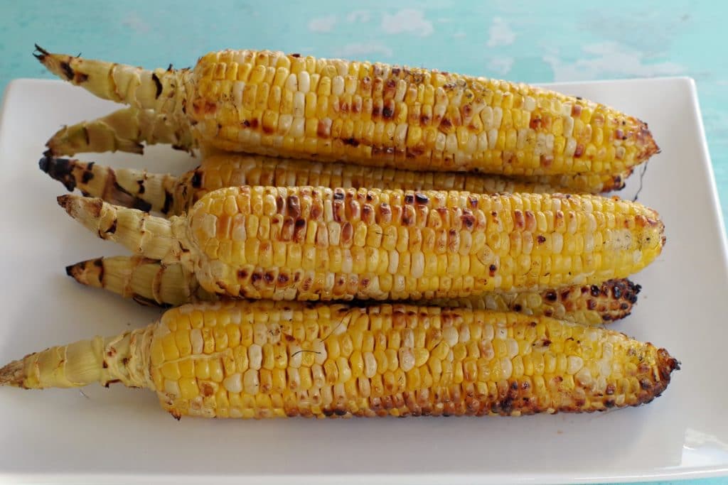 grilled corn on a white platter