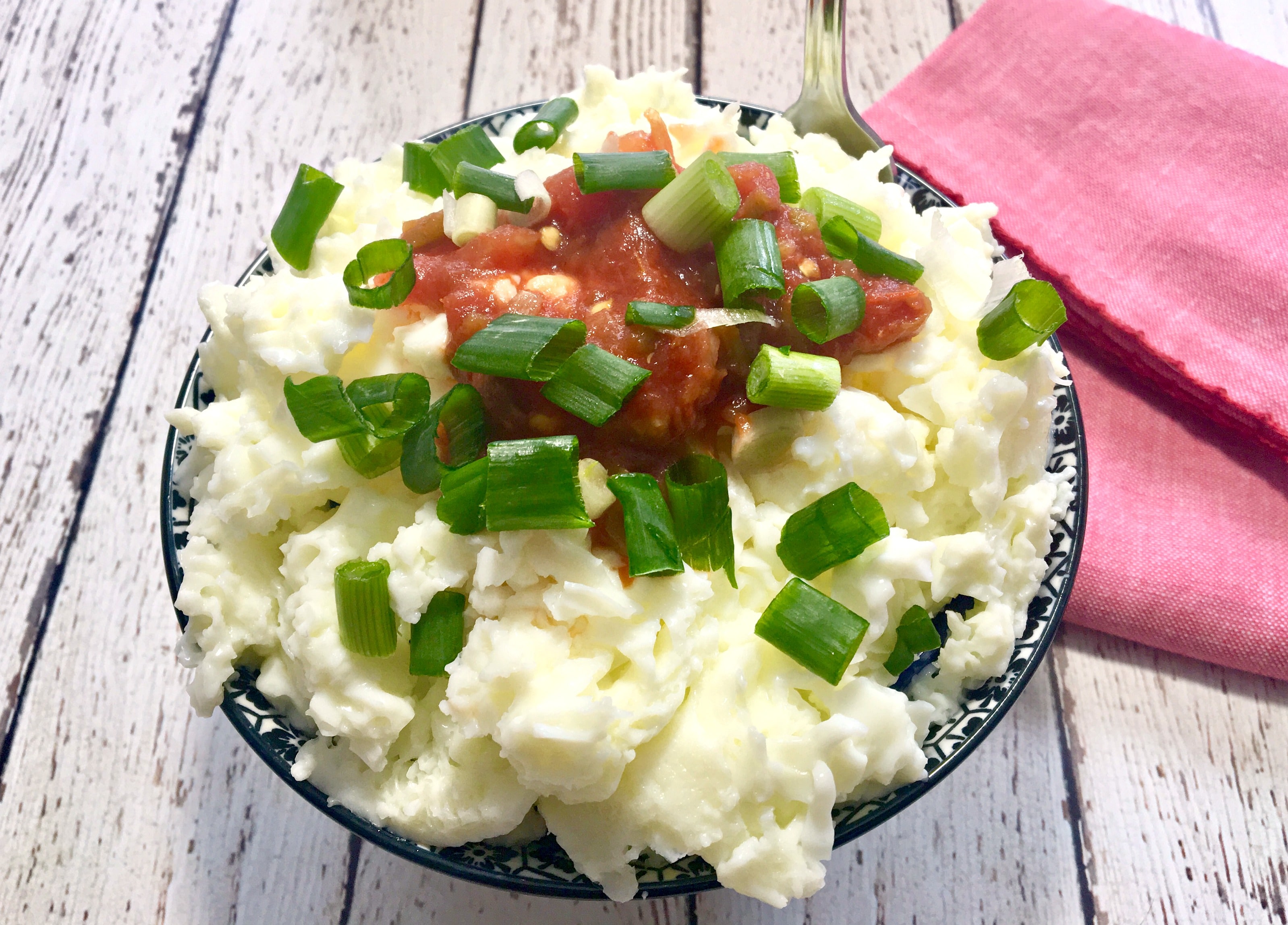 microwaved egg whites with salsa and green onion in bowl with red napkin on the side