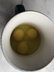 3 raw eggs in a mug