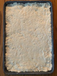 2 ingredient dough spread out to the edges of the baking sheet